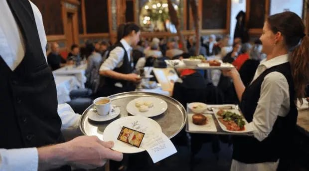 A waiter brings a drink