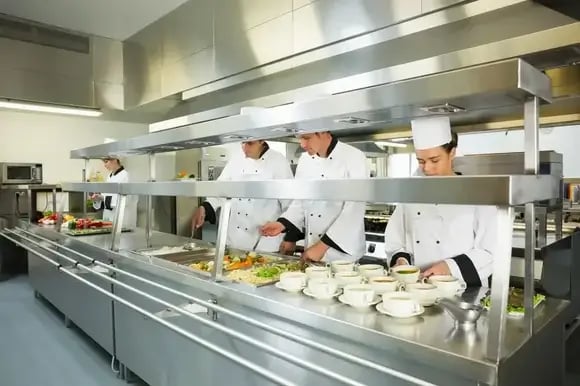 Four chefs working in a big kitchen at service time (1)