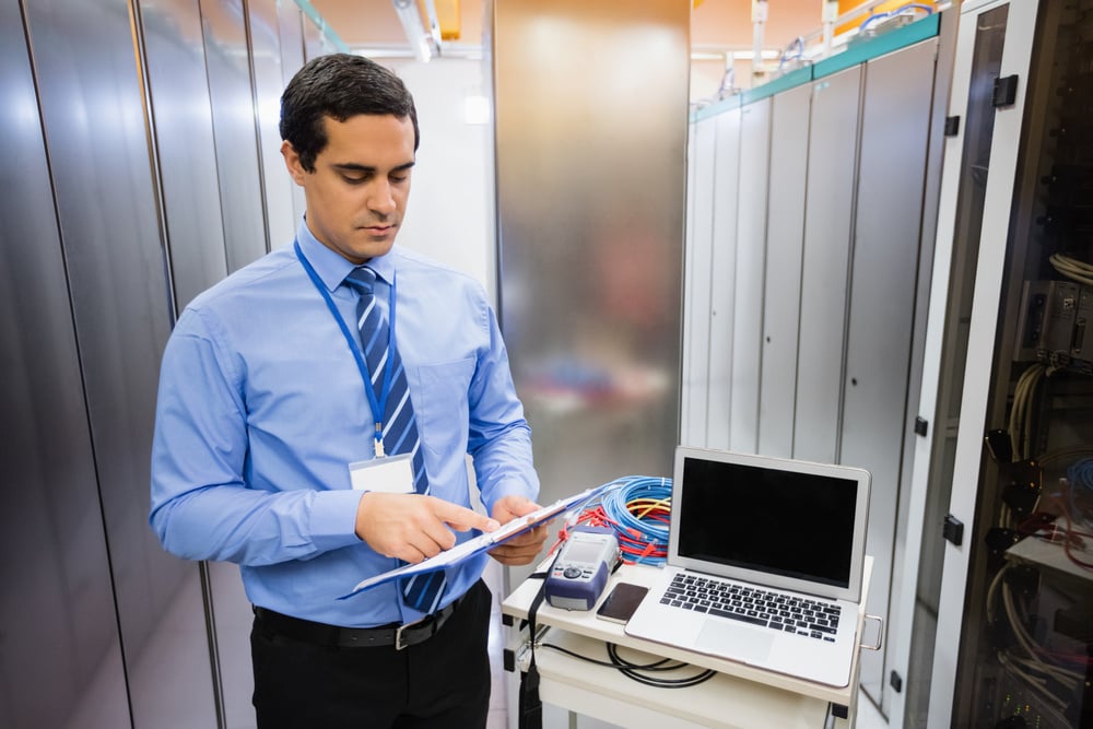 Technician looking at checklist in server room