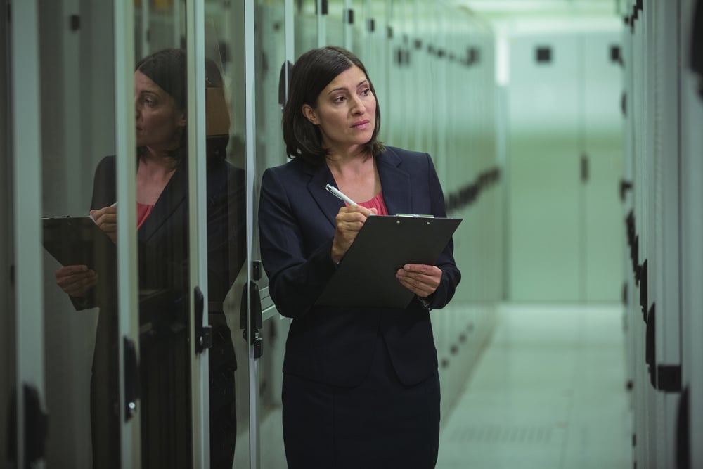 Technician preparing check list in server room